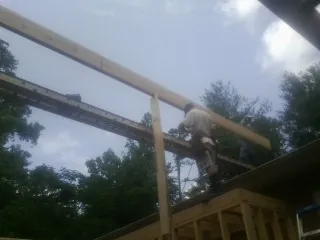 Carpenter setting a ridge beam over a new addition frame — Ice Dam Removal by Roofing Brothers in Worton