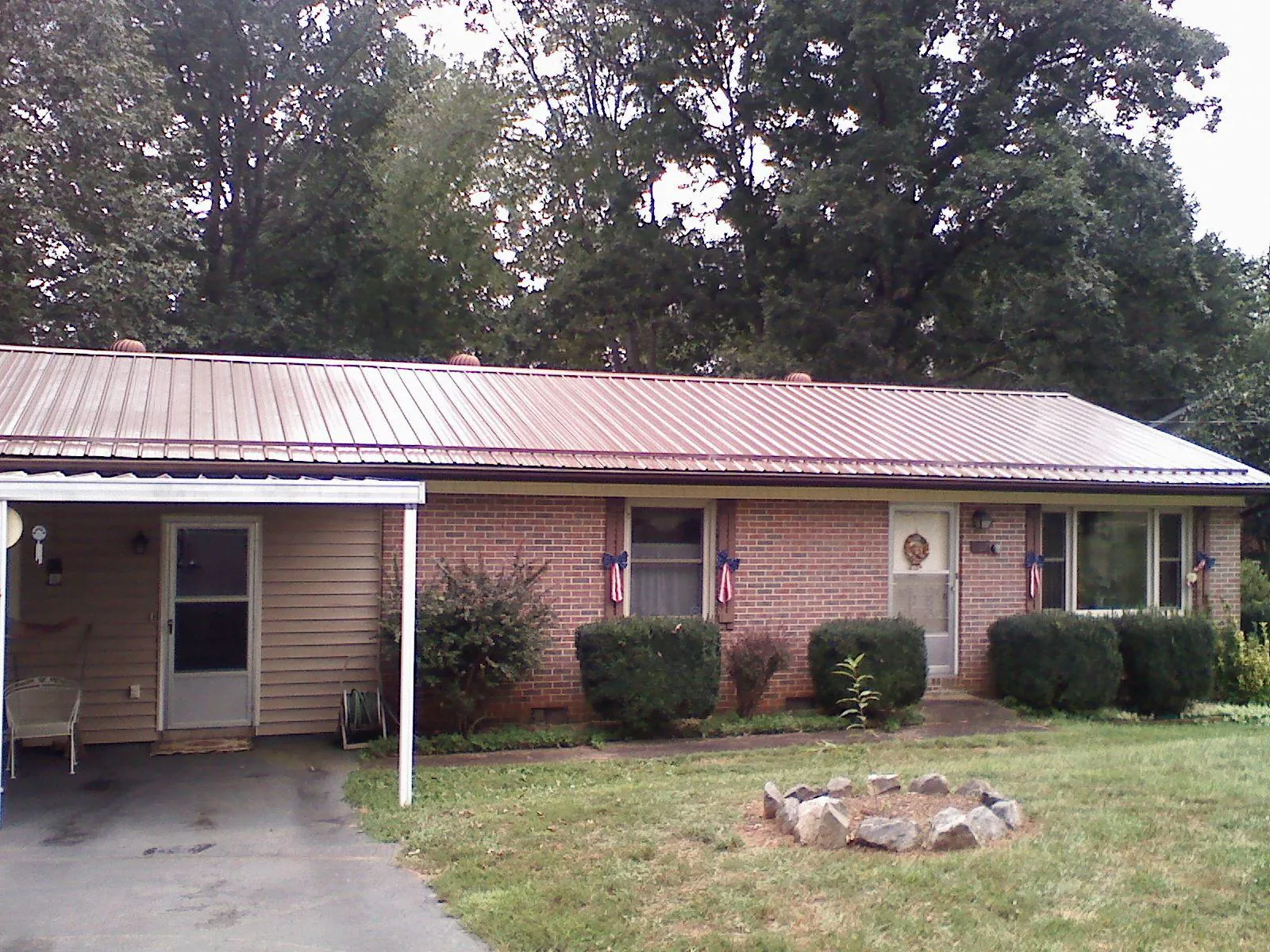 Bronze metal roof and carport on a brick ranch home — Roof Repair work by our crew in Worton